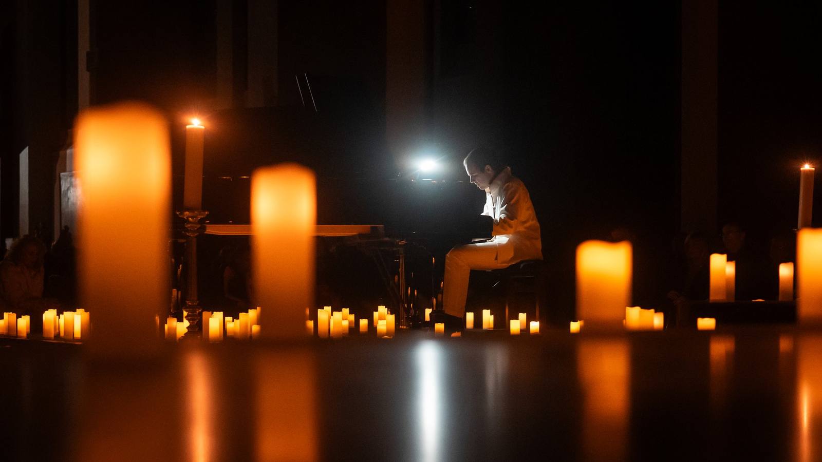 Une nef éclairée par des centaines de bougies pendant un concert